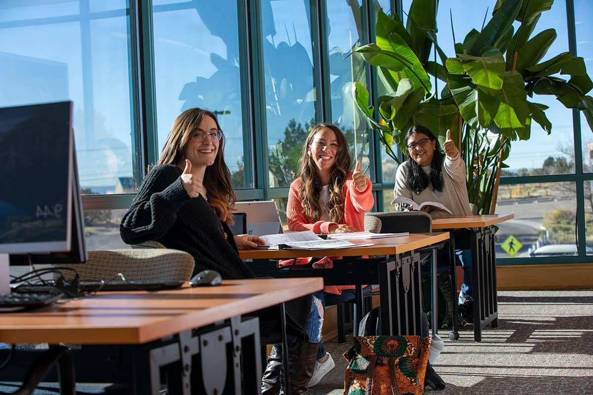 Students giving a thumbs up in the San Juan College Library.